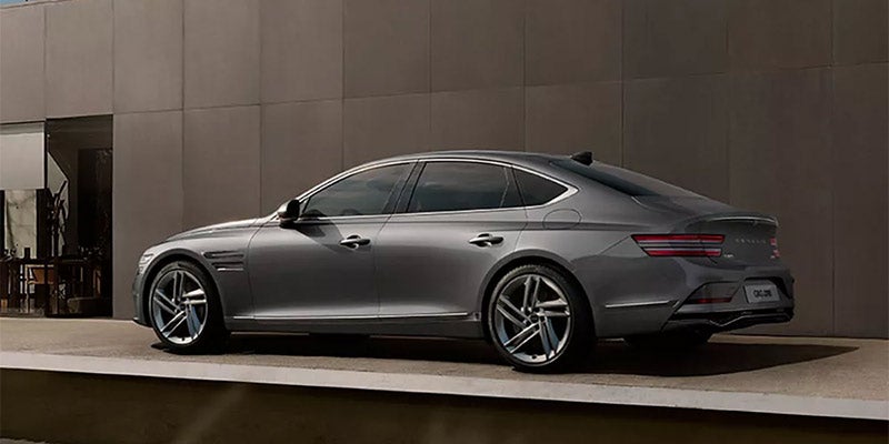 Rear three-quarter view of a silver luxury sedan with sleek LED taillights, tinted windows, and large alloy wheels