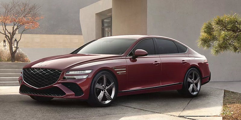 Front three-quarter view of a burgundy luxury sedan with a large mesh grille