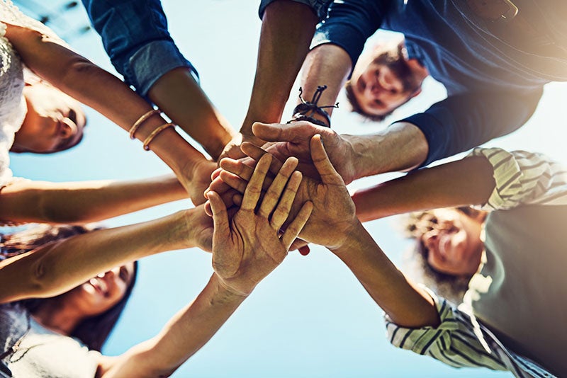 Community members joining hands together